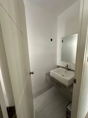 a white bathroom with a sink and a mirror at Town House in Ban Ket Ho