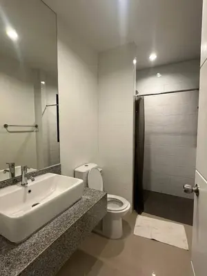 a white bathroom with a sink and a toilet at Town House in Ban Ket Ho