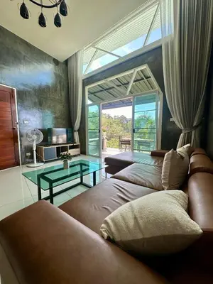 a living room with a couch and a glass table at Amazing Seaview House 2 Bedroom Patong in Patong Beach
