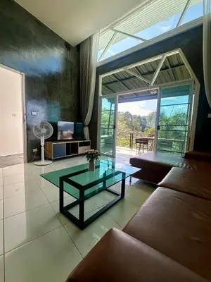 a living room with a couch and a glass table at Amazing Seaview House 2 Bedroom Patong in Patong Beach