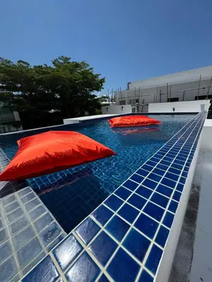 a pool with two red umbrellas on top of it at Villa Rooftop in Ban Saiyuan (1)