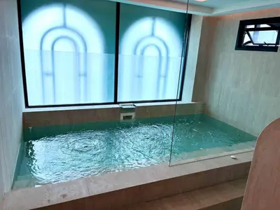 a large tub with a glass window in a bathroom at The Legendary Bang Tao 2-bedrooms apart #402 in Bang Tao Beach