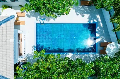 an overhead view of a swimming pool surrounded by trees at Phuket Leisure Time Hotel in Rawai Beach