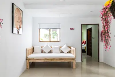 a white couch in a room with a window at Phuket Leisure Time Hotel in Rawai Beach