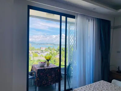 a room with a table and a window with a view at Aristo 2 Condo with a sea view in Surin Beach