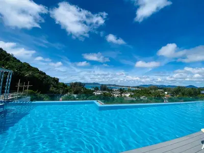 a swimming pool with a blue sky above it at Aristo 2 Condo with a sea view in Surin Beach