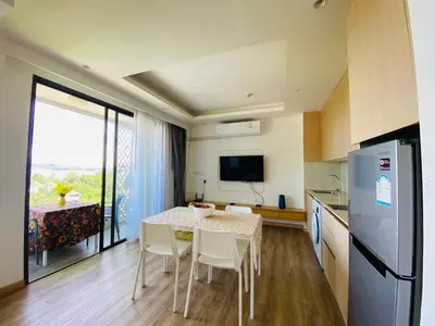 a kitchen and dining room with a table and chairs at Aristo 2 Condo with a sea view in Surin Beach