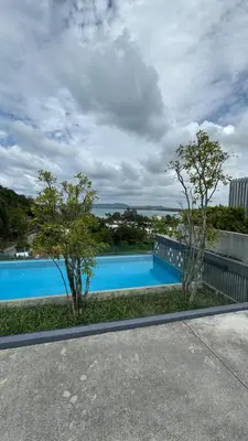 a swimming pool with trees on the side of a building at Aristo 2 Condo with a sea view in Surin Beach