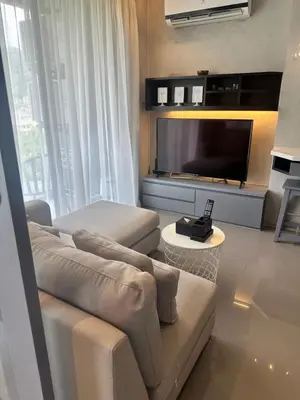 a living room with a couch and a flat screen tv at Kamala City Gate 1 bedroom By Ere P710 in Kamala Beach