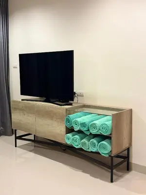 a entertainment center with a flat screen tv and towels at Laguna Park 5 bedroom villa with pool in Laguna Phuket near the beach in Laguna Phuket