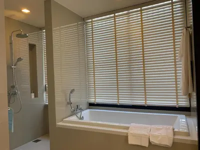 a bathroom with a tub and a shower and a window at Laguna Park 5 bedroom villa with pool in Laguna Phuket near the beach in Laguna Phuket