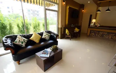 a living room with a leather couch and a table at Breezotel - SHA Certified in Patong Beach