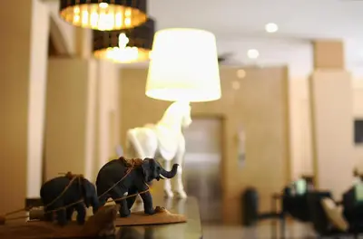 a lamp on a table with a figurine of an elephant at Breezotel - SHA Certified in Patong Beach