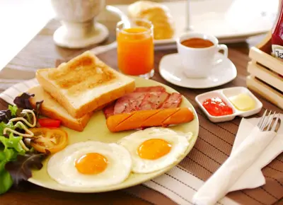 a plate of breakfast food with eggs ham and toast at Breezotel - SHA Certified in Patong Beach