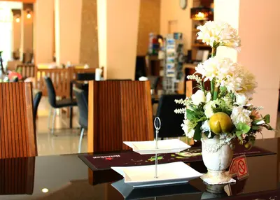 a table with a vase of flowers on top of it at Breezotel - SHA Certified in Patong Beach