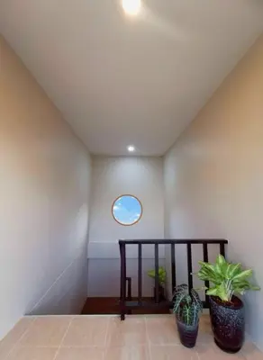 a room with two potted plants and a window at The Pinda House Bangtao in Bang Tao Beach