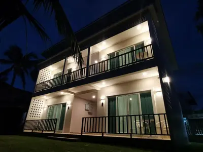 a building with a balcony at night at The Pinda House Bangtao in Bang Tao Beach