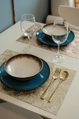 a table with two plates and two wine glasses at La Vita 5 star Super 1 Bdr Nai Harn Beach in Rawai Beach