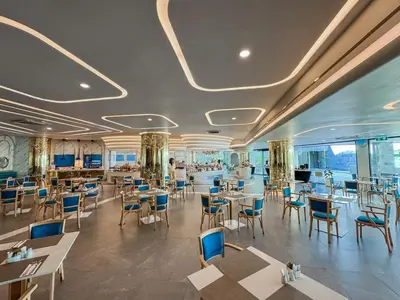 a dining room with tables and chairs and windows at La Vita 5 star Super 1 Bdr Nai Harn Beach in Rawai Beach