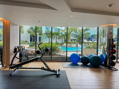 a gym with exercise equipment and a swimming pool at La Vita 5 star Super 1 Bdr Nai Harn Beach in Rawai Beach