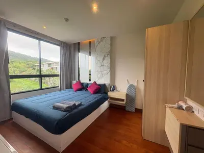 a bedroom with a large bed and a large window at The Lago Nai Harn 2 BR-Walk to beach by ALL HOMES in Rawai Beach