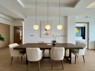 a dining room with a wooden table and chairs at The View Phuket By RESAVA in Kata Beach