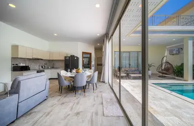 a kitchen and dining room with a table and a pool at Villa Orion at Orbita Villas Rawai in Rawai Beach