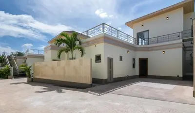 a large white house with a palm tree at Villa Orion at Orbita Villas Rawai in Rawai Beach