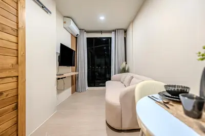 a living room with a couch and a tv at Zcape 1 By SilqStay in Ban Thalat Choeng Thale