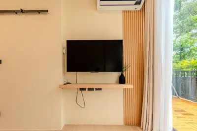 a television on a wall in a room with a window at Zcape 1 By SilqStay in Ban Thalat Choeng Thale