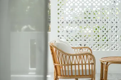 a rattan chair and a table in a room at Nai Harn Beach Holiday Home - Rawai in Rawai Beach