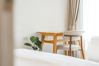 a bedroom with a desk and a chair next to a bed at Nai Harn Beach Holiday Home - Rawai in Rawai Beach
