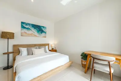 a bedroom with a bed and a desk and a chair at Nai Harn Beach Holiday Home - Rawai in Rawai Beach