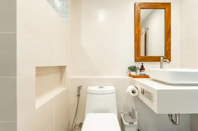 a white bathroom with a toilet and a sink at Nai Harn Beach Holiday Home - Rawai in Rawai Beach