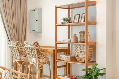 a living room with wooden shelves and chairs at Nai Harn Beach Holiday Home - Rawai in Rawai Beach