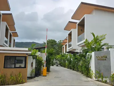 a row of houses on a street with trees at Goldena Residence Pool Villas in Kamala Beach