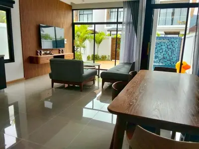 a living room with a table and chairs at Goldena Residence Pool Villas in Kamala Beach