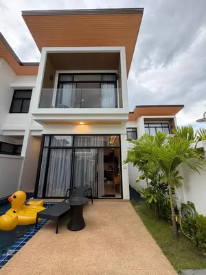 a house with a yellow chair in front of it at Goldena Residence Pool Villas in Kamala Beach