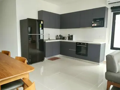 a kitchen with black and white cabinets and a table at Goldena Residence Pool Villas in Kamala Beach