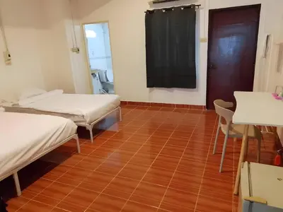 a room with two beds and a wooden floor at xx GO INN Patong Beach Phuket - โก อินน์ หาดป่าตอง ภูเก็ต in Patong Beach