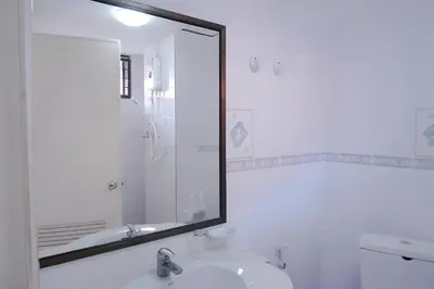 a bathroom with a mirror and a sink at xx GO INN Patong Beach Phuket - โก อินน์ หาดป่าตอง ภูเก็ต in Patong Beach