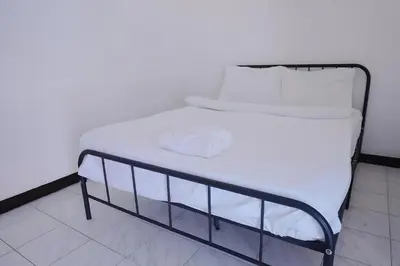 a bed with white sheets and white pillows on it at xx GO INN Patong Beach Phuket - โก อินน์ หาดป่าตอง ภูเก็ต in Patong Beach