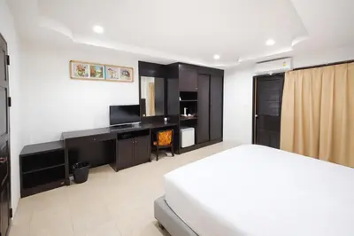 a bedroom with a bed and a desk and a television at Hill Side Patong in Patong Beach