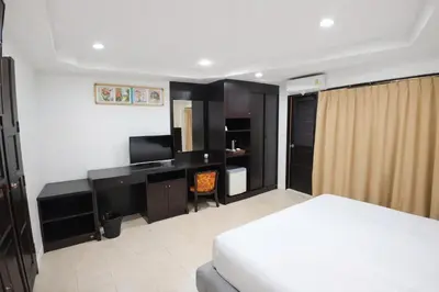 a bedroom with a bed and a desk with a television at Hill Side Patong in Patong Beach