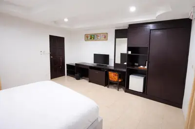 a bedroom with a bed and a desk with a television at Hill Side Patong in Patong Beach