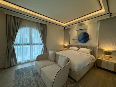 a bedroom with a bed and a couch and a window at Вилла на Бангтао in Ban Thalat Choeng Thale