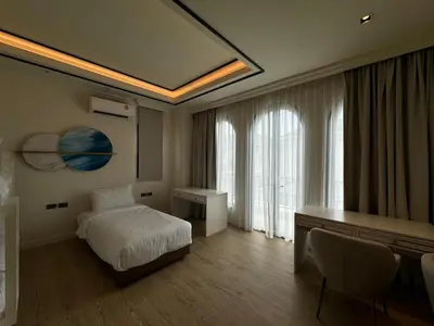 a hotel room with a bed and a desk and window at Вилла на Бангтао in Ban Thalat Choeng Thale