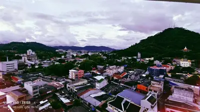 a city with buildings and a mountain in the background at No 498 SPD in Phuket Town