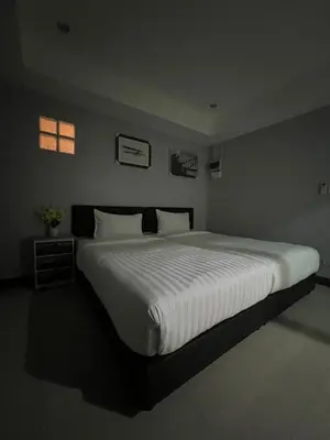 a large white bed in a bedroom with a window at PMS Guest House Patong in Patong Beach
