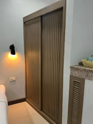 a wooden door in a room with a light at PMS Guest House Patong in Patong Beach